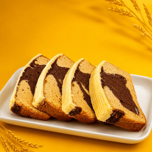 Davkem sliced marble cake on a plate with chocolate and vanilla swirl on a yellow background.